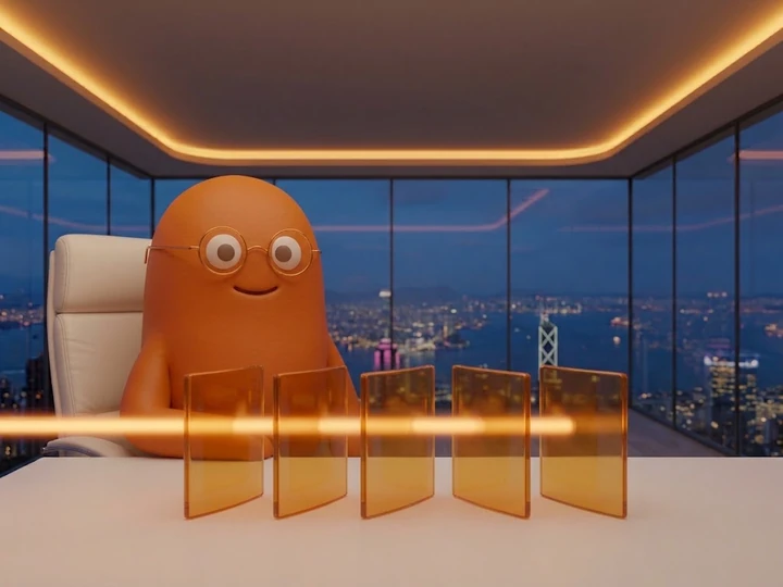 The orange mascot behind five tall amber glass panels with a soft beam of light passing through them